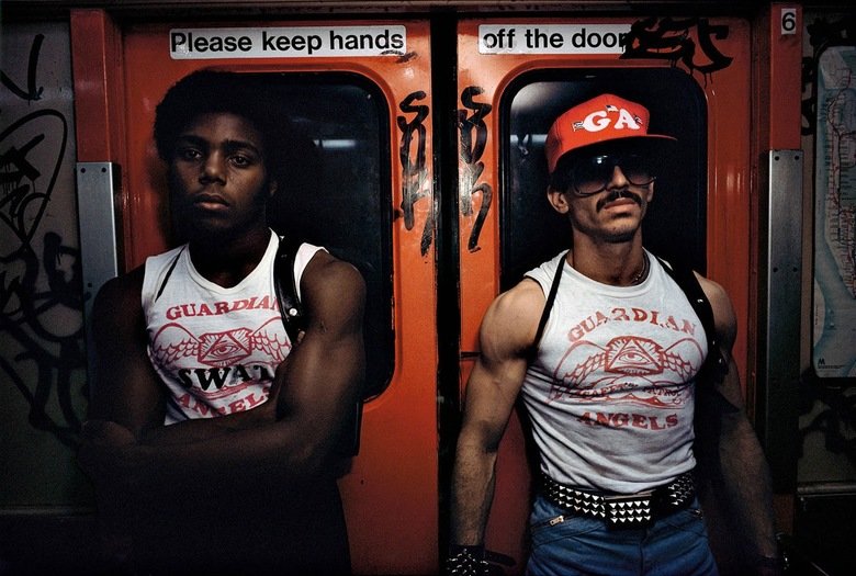Historical picture comp 4. Worker and supervisor at a car factory, Moscow, 1954 Guardian Angels on the NYC subway, 1980. Native American smoke curing a human co